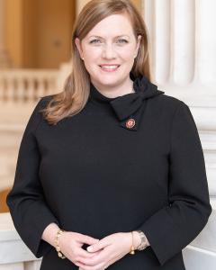 Elizabeth Fletcher wearing dark blazer and light blue blouse while standing outside