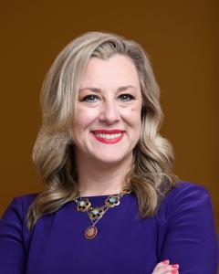 Kendra Horn in a purple dress smiling