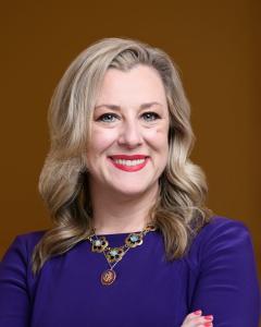 Kendra Horn in a purple dress smiling