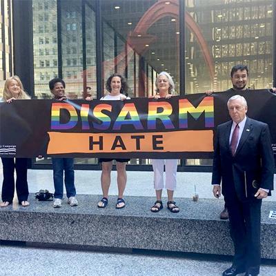 Hoyer stands together with Chicagoans for gun violence prevention holding a rainbow banner that says "Disarm Hate"